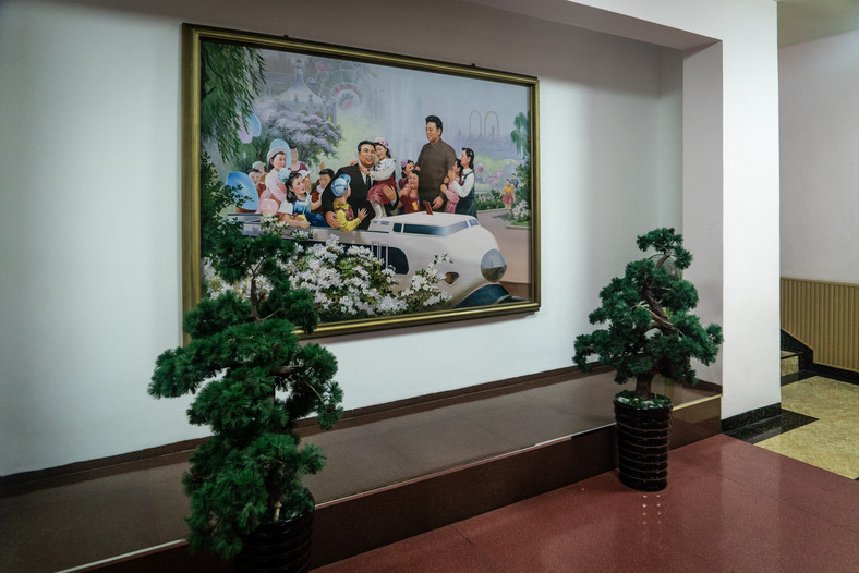 Wejscie do szkoły - obraz Kim Ir sena i Kim Dzong Ila w otoczeniu dzieci