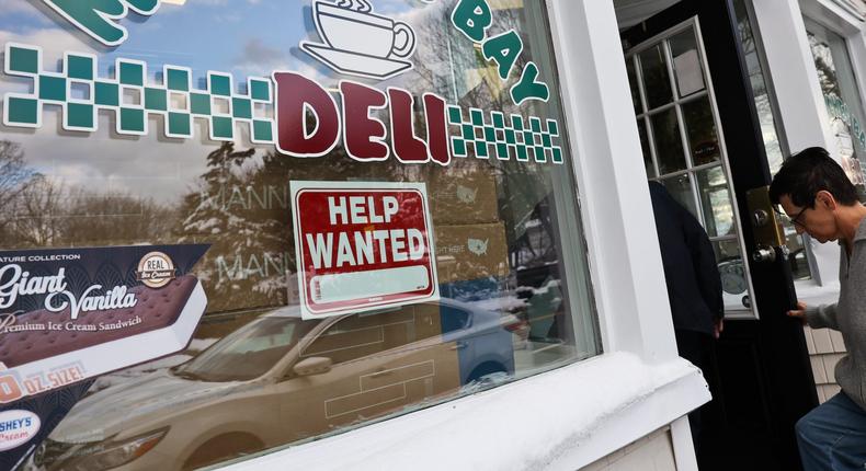 East Moriches, N.Y.: Photo of a help wanted sign displayed in the front window of the Moriches Bay Deli in East Moriches, New York, on January 7, 2022.