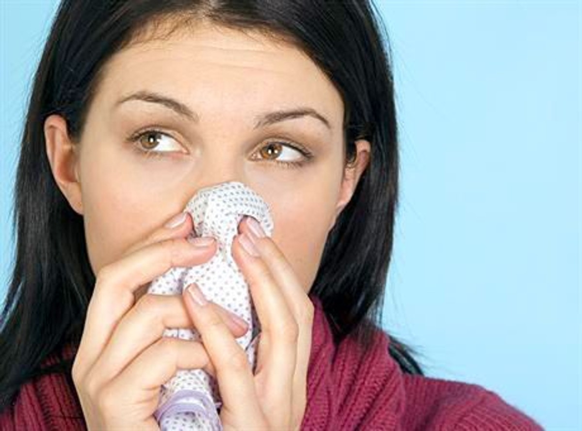 WD 1018-15  MODEL RELEASED.  Brunette female with long hair, wearing a raspberry roll neck jumper, looking to side and blowing her nose with a spotty handkerchief.  Obligatory Credit - CAMERA PRESS  Richard Stonehouse