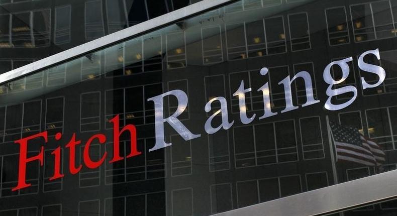 A flag is reflected on the window of the Fitch Ratings headquarters in New York February 6, 2013. REUTERS/Brendan McDermid