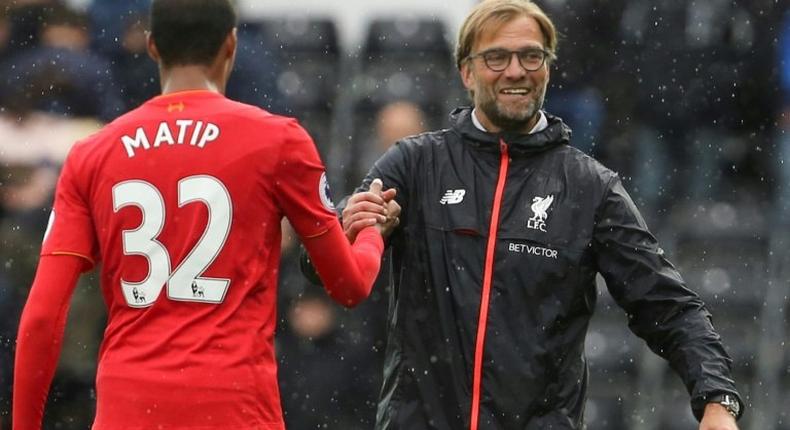 Liverpool's German manager Jurgen Klopp (R) shakes hands with Cameroonian defender Joel Matip (L) on October 1, 2016