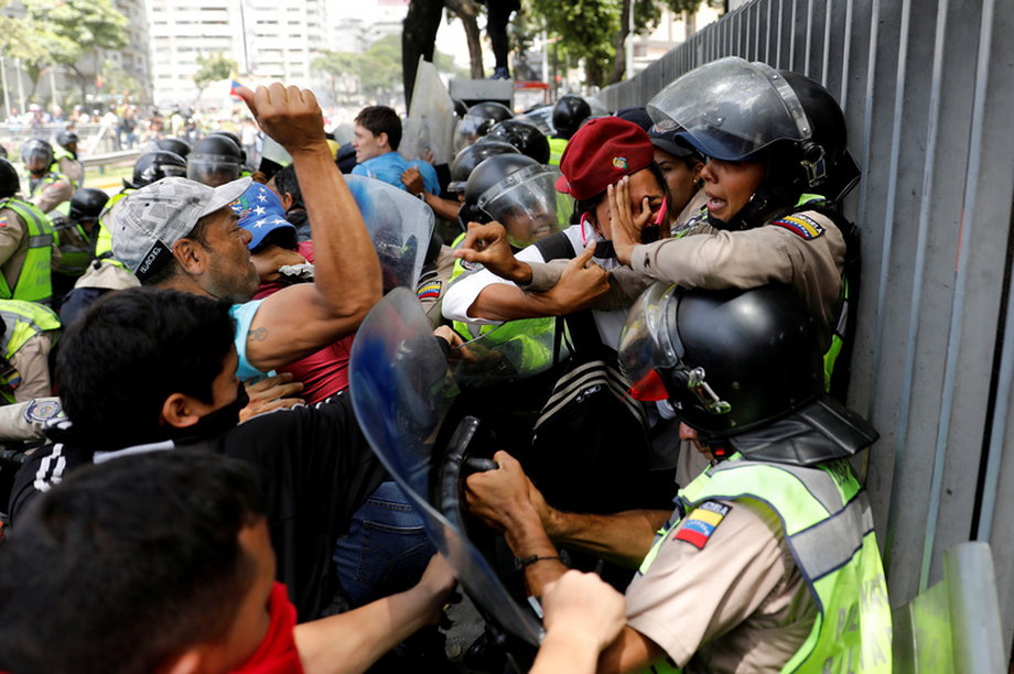 Demonstrators scuffle with security forces during an opposition rally in Caracas