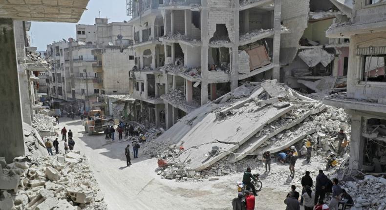 Members of the Syrian Civil Defence, also known as the White Helmets, search the rubble of a collapsed building following an explosion in the town of Jisr al-Shughur, in the mostly rebel-held Syrian province of Idlib, on April 24, 2019