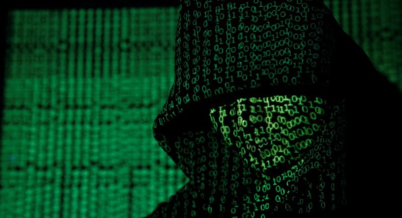 Projection of cyber code on hooded man is pictured in this illustration picture