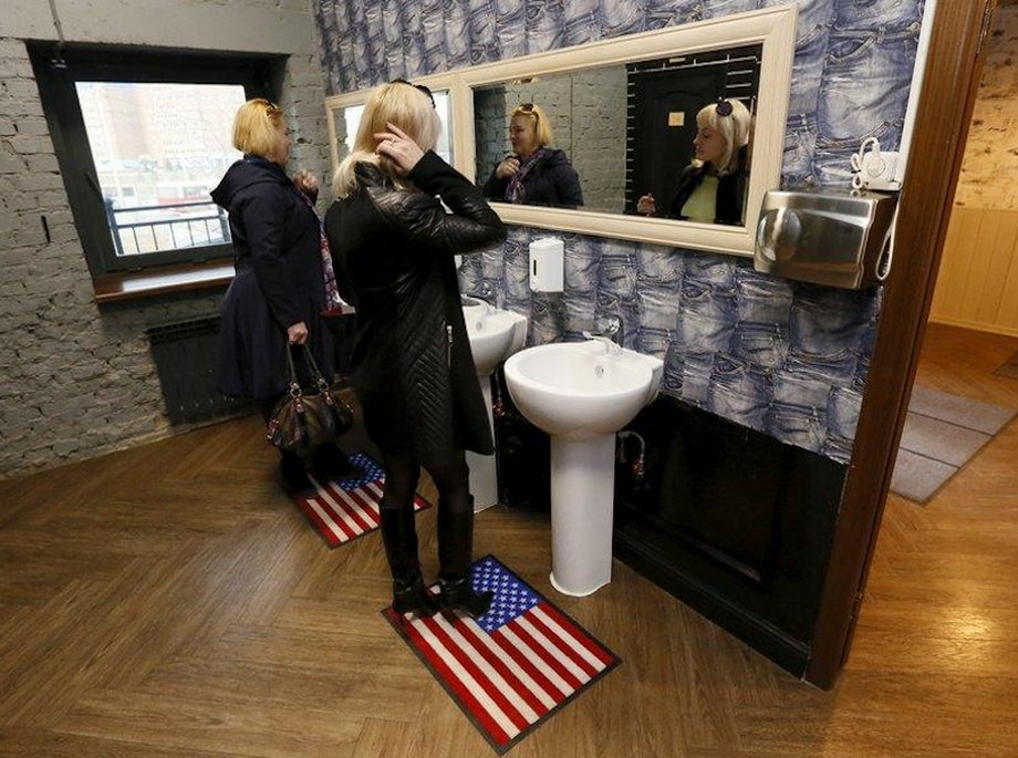 Visitors stand on rugs depicting the US flag in a toilet at the "President Cafe" in Krasnoyarsk, Siberia, Russia, April 7, 2016.