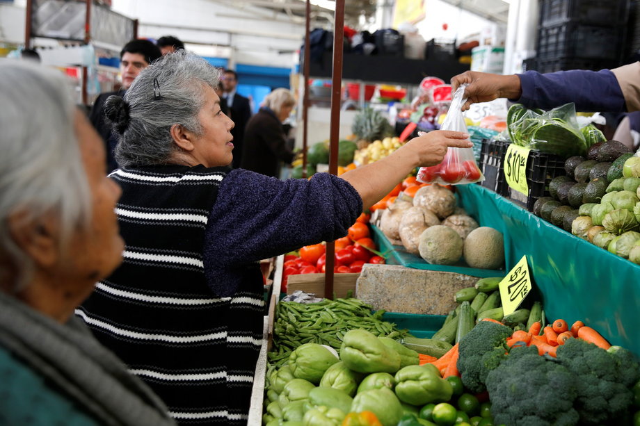 A woman buys tomatoes in a groceries stall at Granada market in Mexico City, Mexico, January 10, 2017.