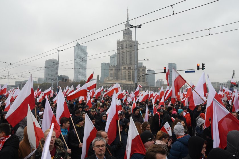 Uczestnicy Marszu Niepodległości na tle Pałacu Kultury w Warszawie