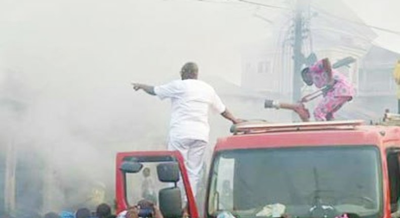 Governor Ayo Fayose joins firemen to put out a fire. 