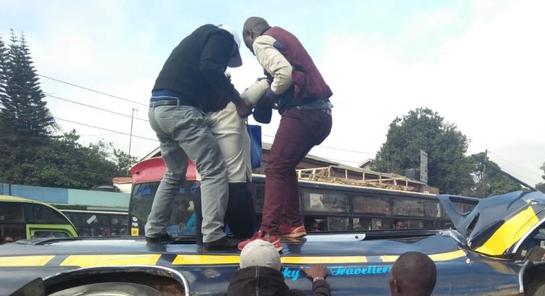 Members of the public assist passengers on 14-seater matatu that overturned at Ngara along Murang'a Road