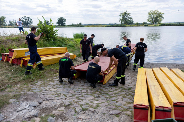 Strażacy ustawiają specjalną zaporę, której zadaniem będzie zatrzymywanie śniętych ryb płynących z nurtem Odry,