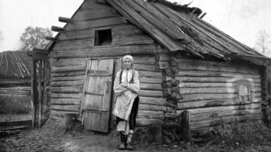 Poleska kobieta przed chatą.