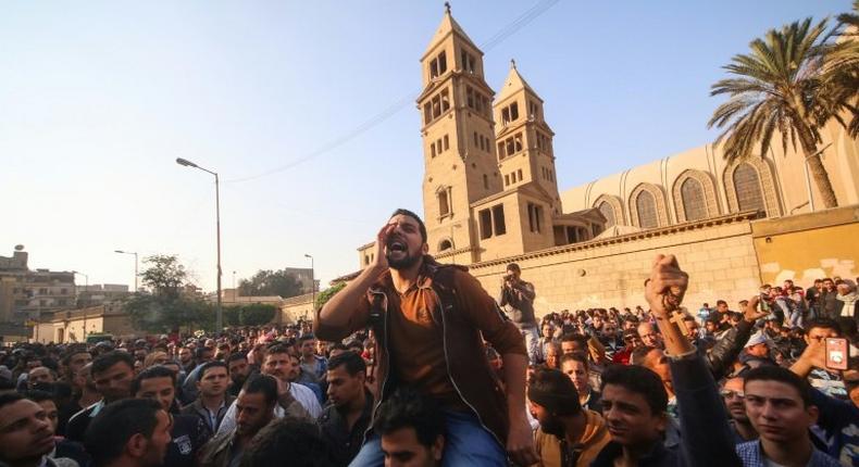 Egyptians gather outside the Saint Peter and Saint Paul Coptic Orthodox Church in Cairo on December 11, 2016