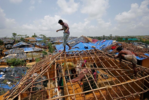 Rohingya refugees rebuild their makeshift house, which was destroyed by Cyclone Mora, at the Kutupal