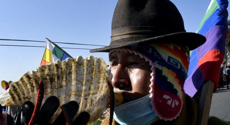 An Amauta, a priest of Bolivia's indigenous Aymara community, blows an instrument during an anti-government march