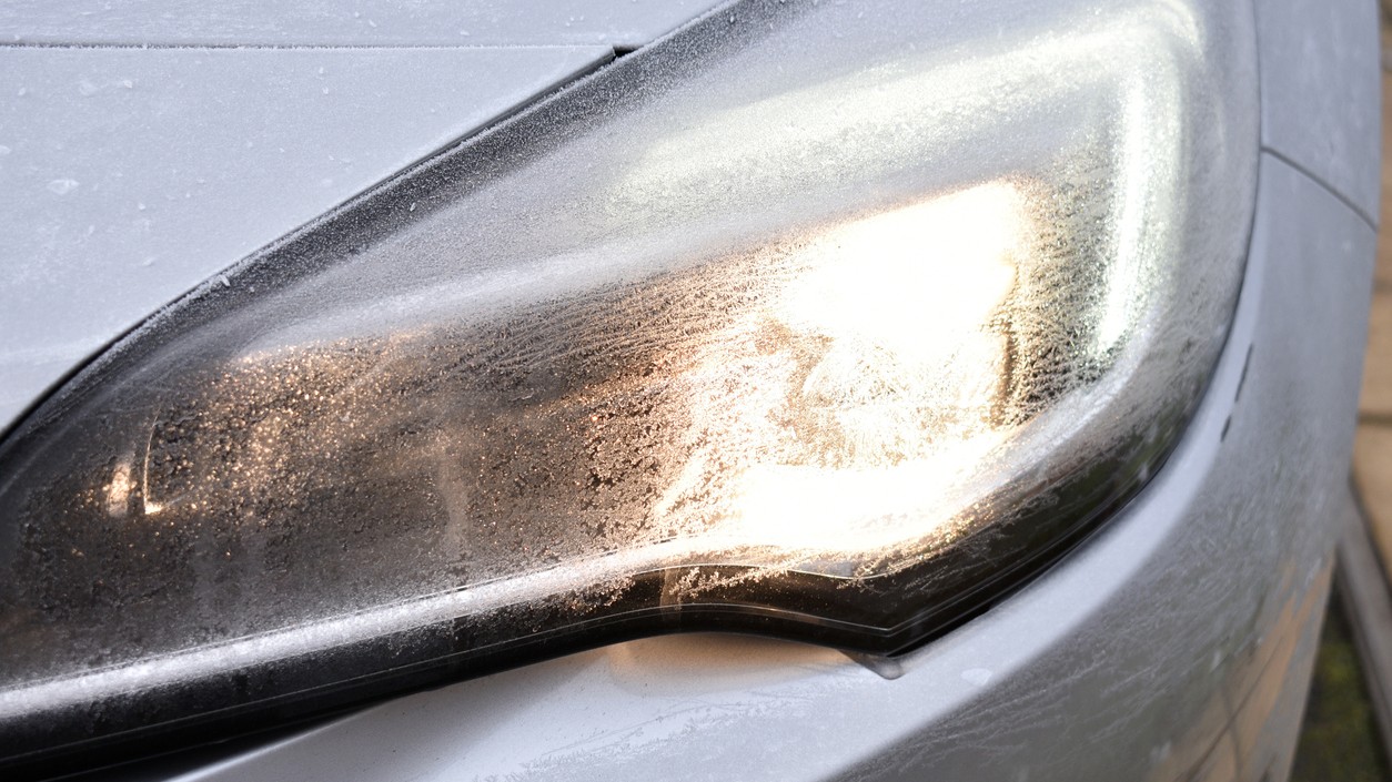 Detailný záber na moderné LED svetlomety, ktoré v noci osvetľujú cestu pred vozidlom. 