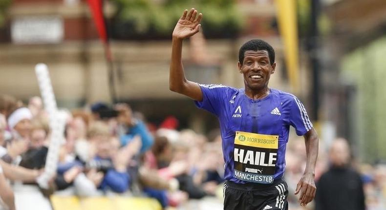 Ethiopia's Haile Gebrselassie waves as he approaches the finish line at the end of the Morrisons Great Manchester Run. 