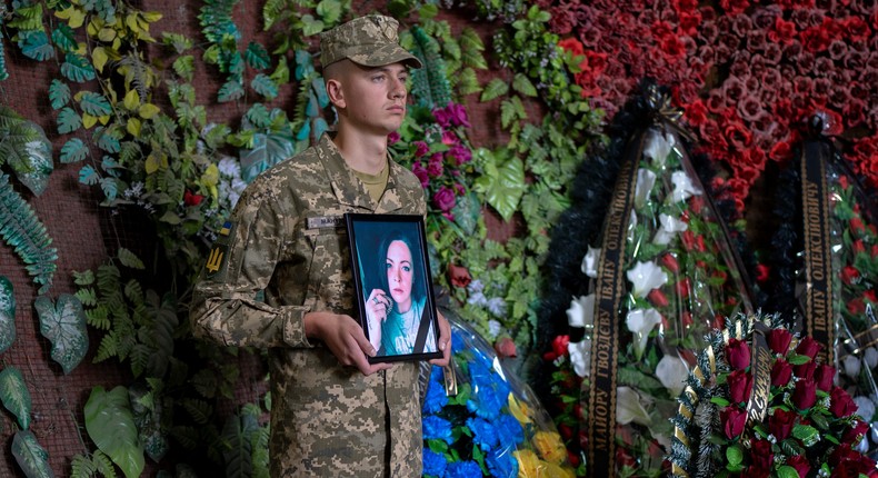 A Ukrainian soldier holds a photo of Olga Simonova, 34, a Russian woman who was killed in the Donetsk region while fighting on Ukraine's side in the war with her native country, in a crematorium in Kyiv, Ukraine, Friday, Sept. 16, 2022.