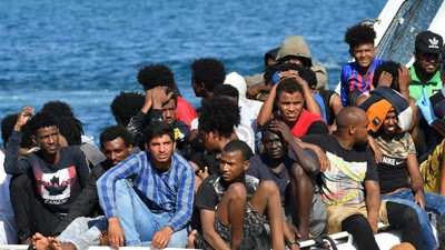 Migrants from Tunisia and Libya arrive onboard of an Italian Coast Guard boat on the Italian island of Lampedusa on August 1