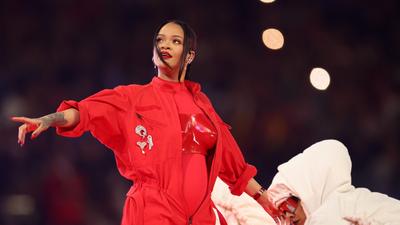 Rihanna baby bump peeping through her jumpsuit [Gettyimages]