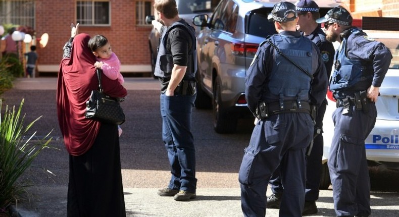 Police direct locals around a block of flats in the Sydney suburb of Lakemba after counter-terrorism raids across the city