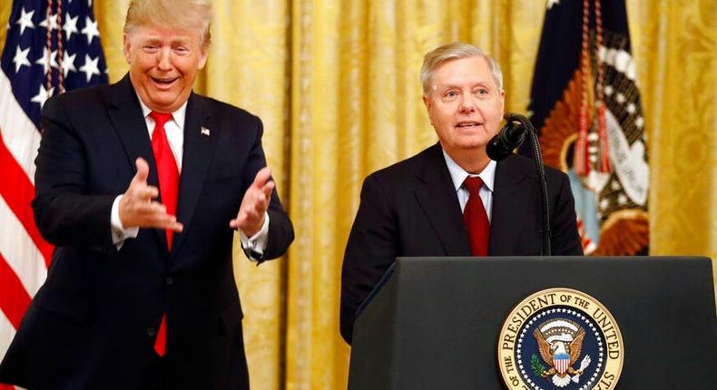 Then-President Donald Trump gestures as Sen. Lindsey Graham speaks about an upcoming afternoon vote in the Senate during an event in the White House on November 6, 2019.