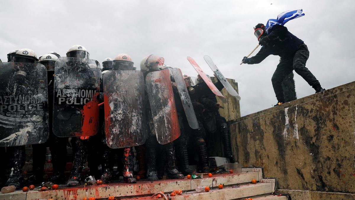 Protesters clash with police officers during a demonstration against the agreement reached by Greece