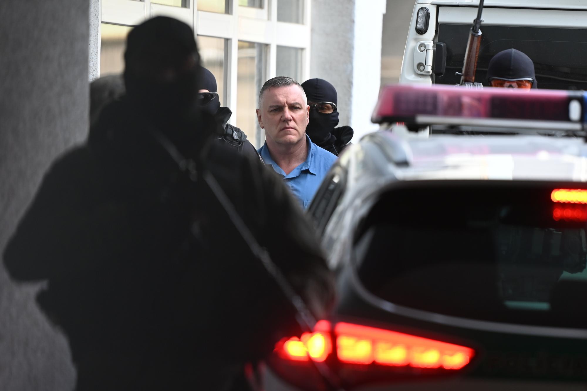 Odsúdený Mikuláš Černák prichádza v sprievode eskorty na verejné zasadnutie okresného súdu Trnava.