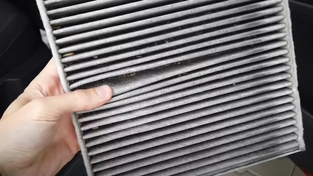 Znečistený poletový filter z klimatizácie auta – sivohnedá vrstva nečistôt – živnou pôdou pre baktérie a plesňové spóry, ktoré vodič následne vdychuje. 