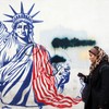 Iranka pored antiameričkog murala u Teheranu