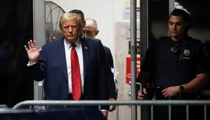 Donald Trump waves to reporters as he enters the courtroom for his hush-money trial in New York.Reuters/Spencer Platt