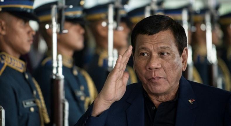 Philippine President Rodrigo Duterte walks past honour guards