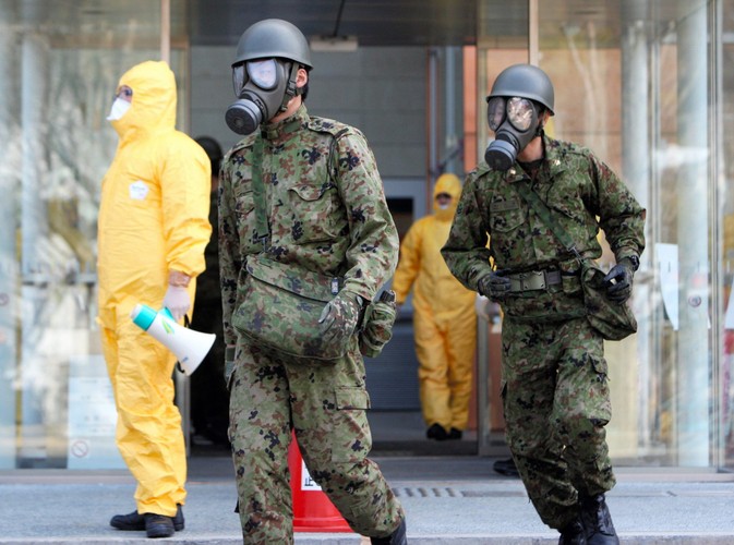 Japońskie siły samoobrony w mundurach i maskach w wiosce Otama w prefekturze Fukushima