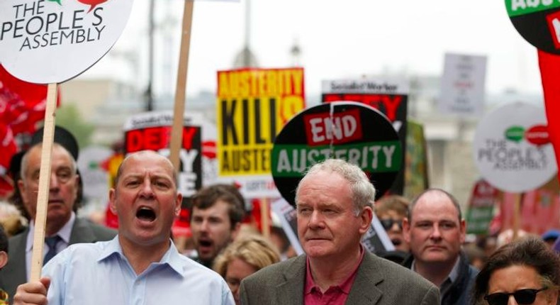 Northern Ireland Deputy First Minister Martin McGuinness hold a banner as he marches during an anti-austerity protest in central London