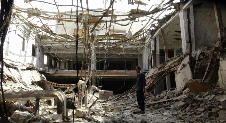 A man inspects the ruins of a factory hit by fierce fighting for the Yemeni port city of Hodeida that a UN-brokered truce which went into effect on Tuesday is intended to halt