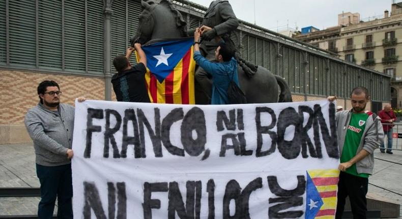 Protestors hang a Catalan Pro-independence flag on a headless sculpture of Francisco Franco riding a horse during the unveiling of the statue