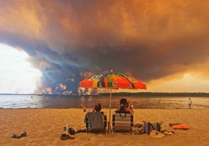 Posetioci plaže odmaraju se na plaži Mučik na obali jezera Lakano u Lakanou, na jugozapadu Francuske, dok požar besni u Žirondi, 24. jul 2026.