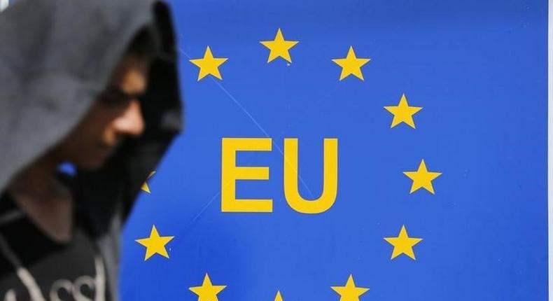 A migrant walks next to an EU sign at the border with Serbia in Tovarnik, Croatia September 17, 2015. REUTERS/Antonio Bronic