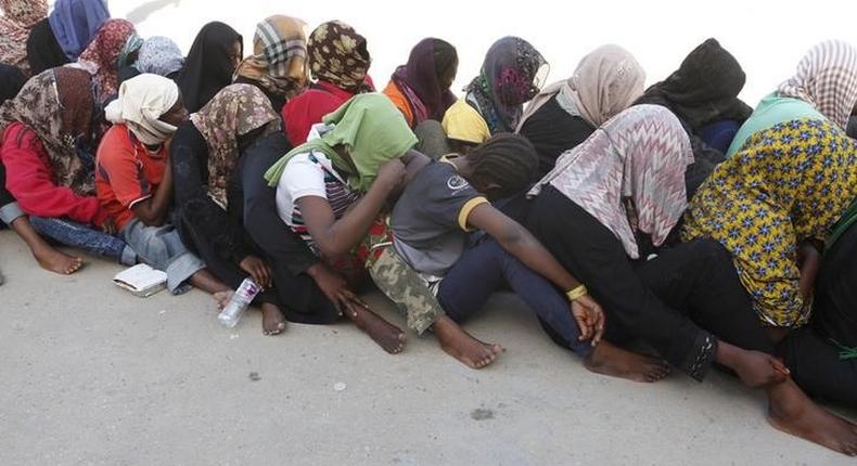 Illegal migrants sit at temporary detention centre after they were detained by Libyan authorities in Tripoli, Libya October 12, 2015. REUTERS/Ismail Zitouny