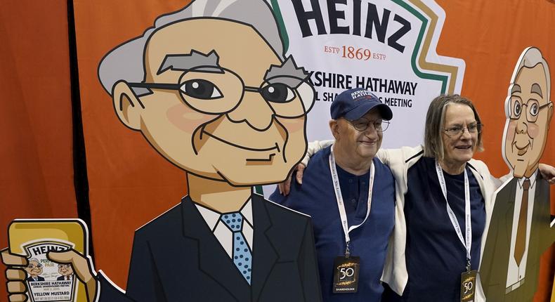 Berkshire Hathaway shareholders pose with likenesses of Berkshire CEO Warren Buffett, left, and vice chairman Charlie Munger at the shareholders' shopping day in Omaha, Nebraska.