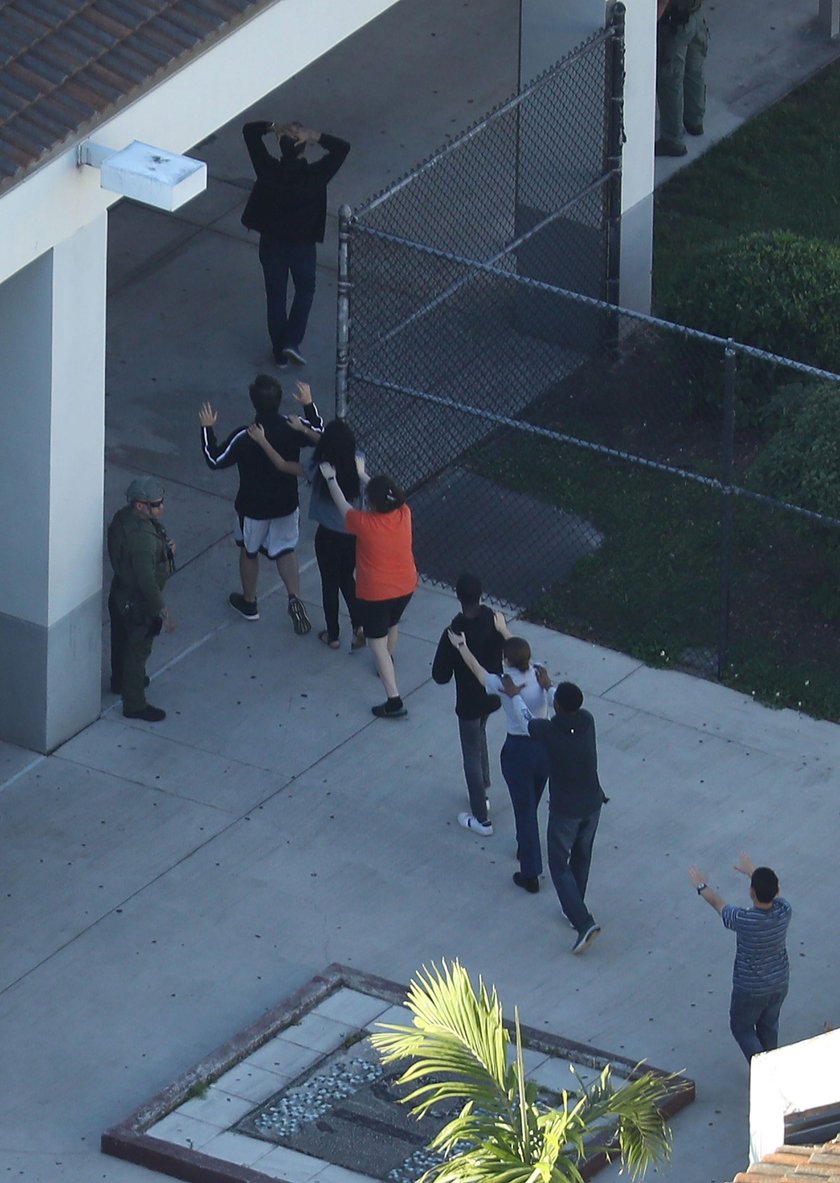 Police escort a suspect into the Broward Jail after checking him at the hospital following a shootin