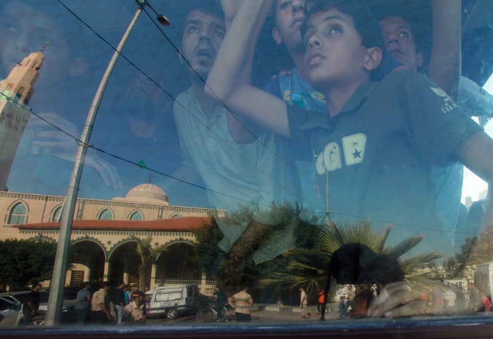 Palestinians look out of a bus window during the funeral of al-Nimim in Gaza City