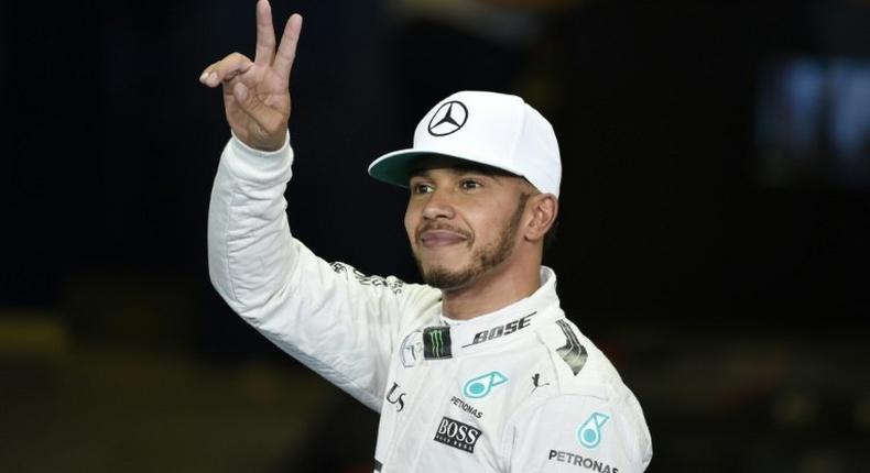 The Mercedes F1 Team's British driver Lewis Hamilton gestures after taking pole in qualifying session as part of the Abu Dhabi Formula One Grand Prix at the Yas Marina circuit on November 26, 2016