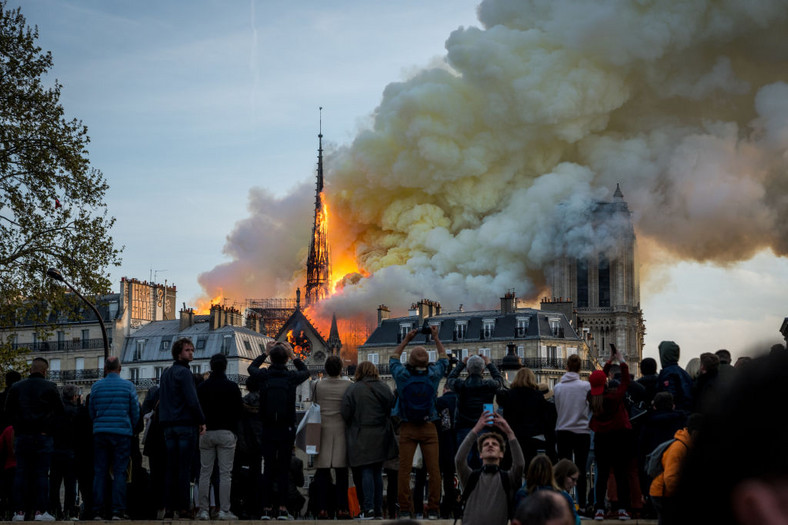 Ludzie patrzą na płonącą katedrę Notre-Dame (15 kwietnia 2019)