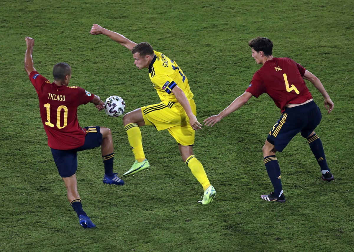 Szwed Viktor Claesson (C) w starciu z Thiago Alcantarą (L) i Pau Torresem (P) w trakcie meczu Hiszpanów ze Szwedami w Sewilli