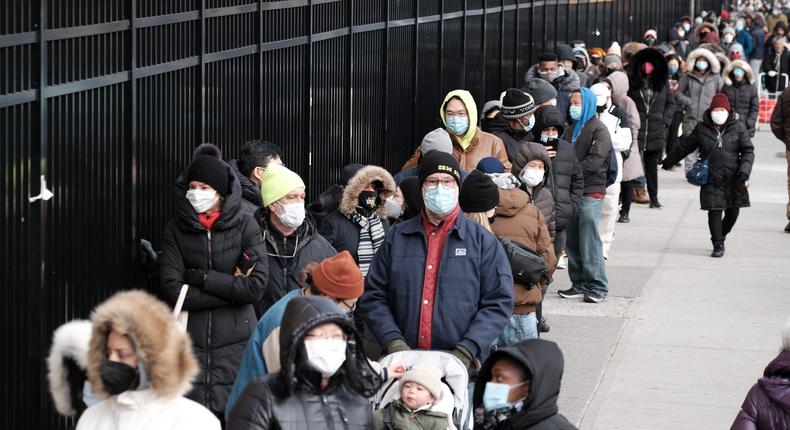 People wait in line as city workers hand out take-home COVID-19 tests in lower Manhattan on December 23, 2021.