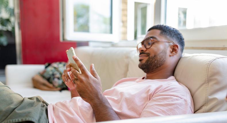 Man on couch watching videos on phone