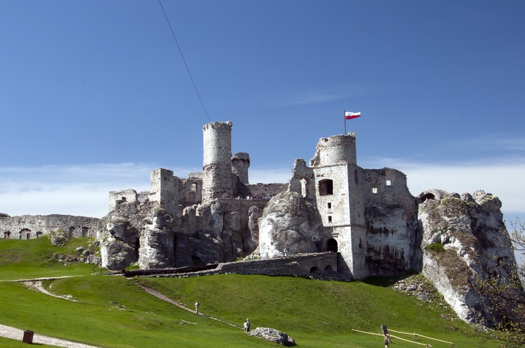 7. Ogrodzieniec Początki Zamku Ogrodzieniec sięgają czasów panowania Piastów. Znajduje się on (a jakżeby inaczej) na Szlaku Orlich Gniazd, wzniesionego do łatwiejszej obrony południowych granic. Niesamowity, największy na Jurze Krakowsko-Częstochowskiej zamek przyciąga tłumy turystów – często wskazywany jako najpiękniejszy obiekt tego terenu. Pamiętaj, szczególnie w sezonie zimowym, że budowlę można zwiedzać jedynie przy sprzyjających warunkach pogodowych, bez oblodzeń, śniegu lub deszczu. I jeszcze drobna wskazówka lokalizacyjna: zamek znajduje się w Podzamczu, a nie w miejscowości Ogrodzieniec. Warto wspomnieć o romantycznym akcencie związanym z tym miejscem – podobno Jan Sobieski pisał listy do swojej ukochanej Marysieńki, gdy stacjonował pod Ogrodzieńcem ze swoimi żołnierzami.