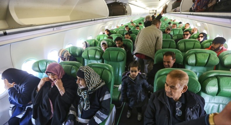 Passengers board and sit inside an aircraft at Mitiga airport, east of the Libyan capital Tripoli