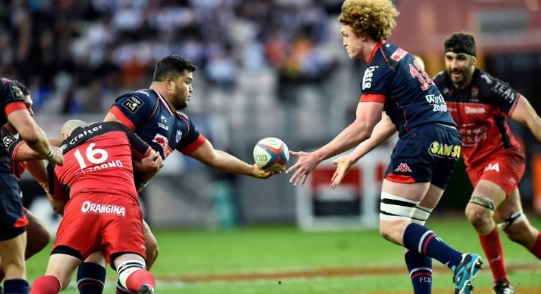 Grenoble's prop Ali Oz (L) passes the ball to lock Thomas Jolmes on March 19, 2016