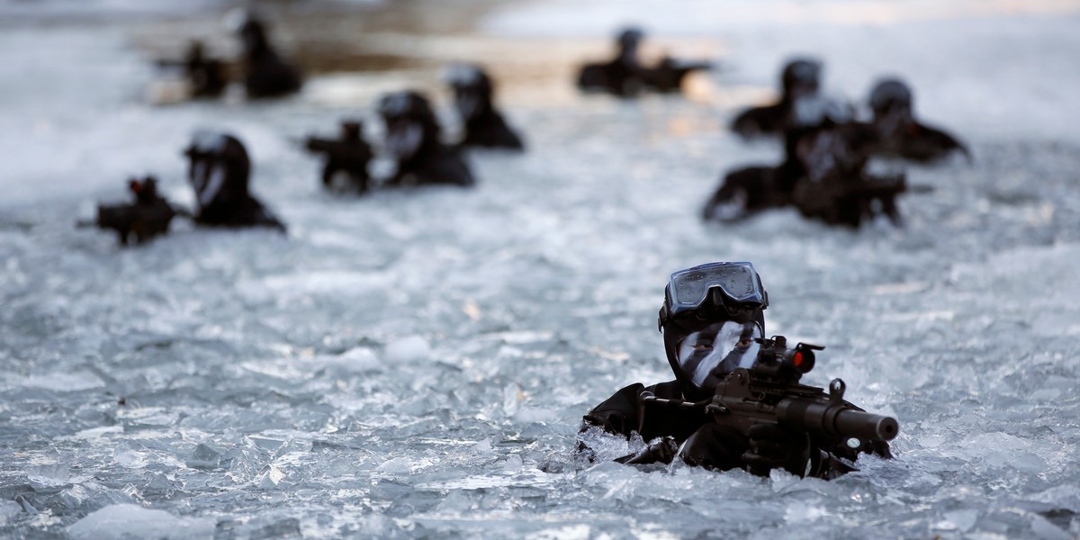 Members of the South Korean Special Warfare Forces take positions in frozen waters during a winter exercise in Pyeongchang, January 8, 2015.